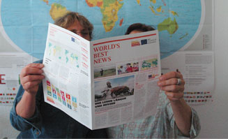 Zwei Personen lesen in der World's Best News.